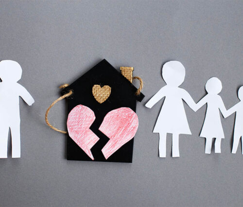 Paper chain cut family with broken heart near toy house on gray background. Divorce and broken family concept.