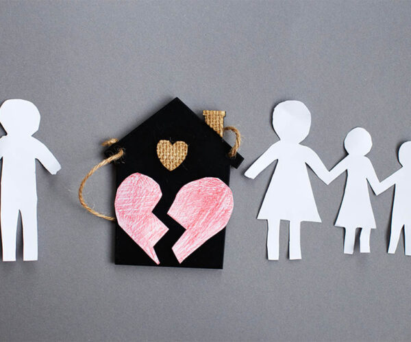 Paper chain cut family with broken heart near toy house on gray background. Divorce and broken family concept.